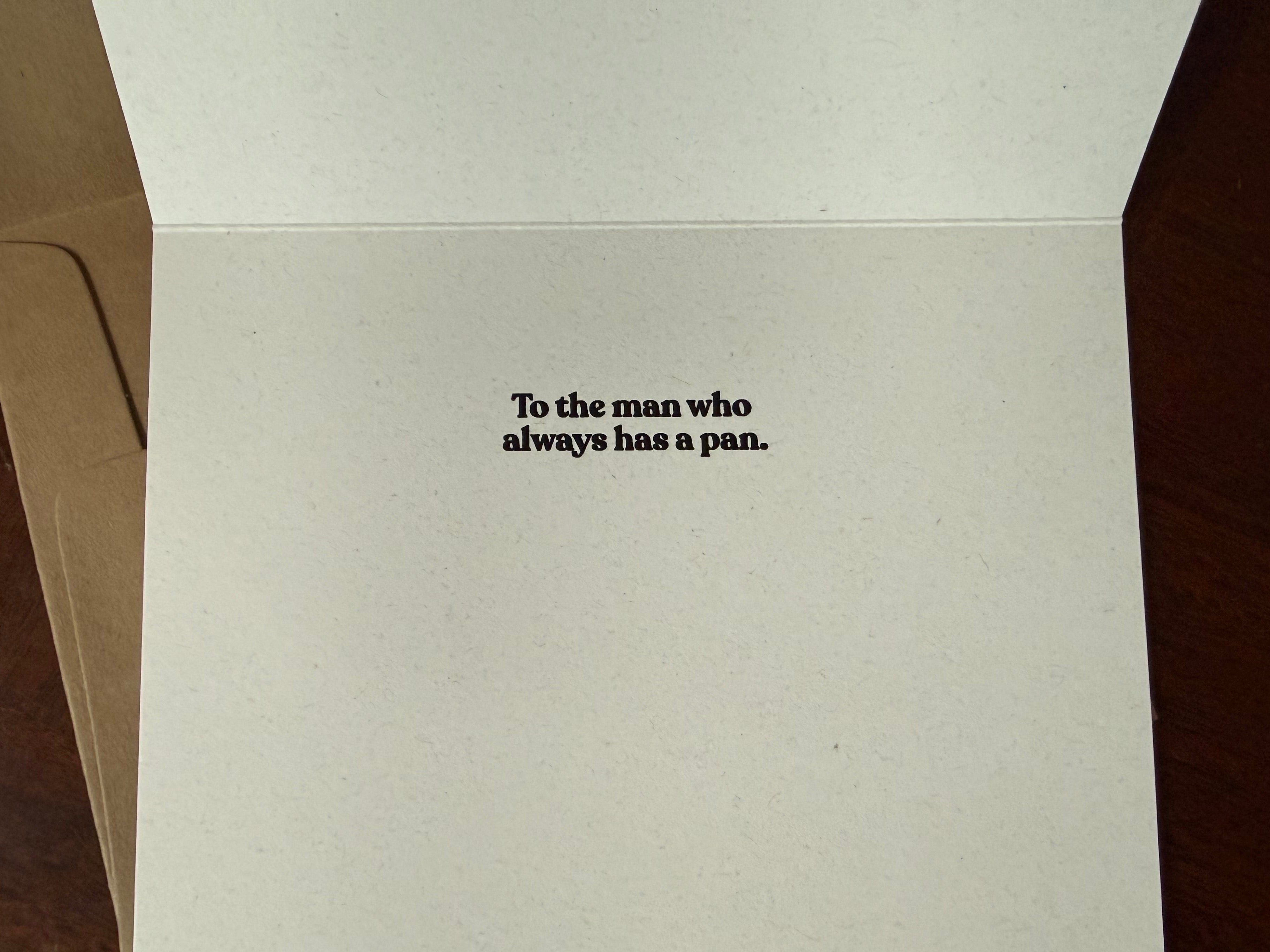 Greeting card with text 'To the man who always has a pan.' on a plain background